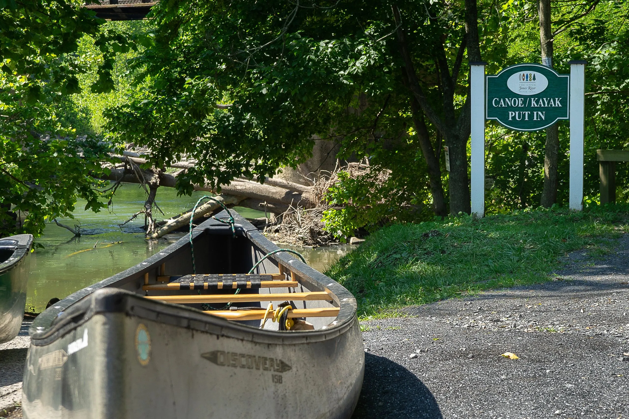 A wooden Town of Glasgow sign at the canoe put-in directing paddlers to the river.