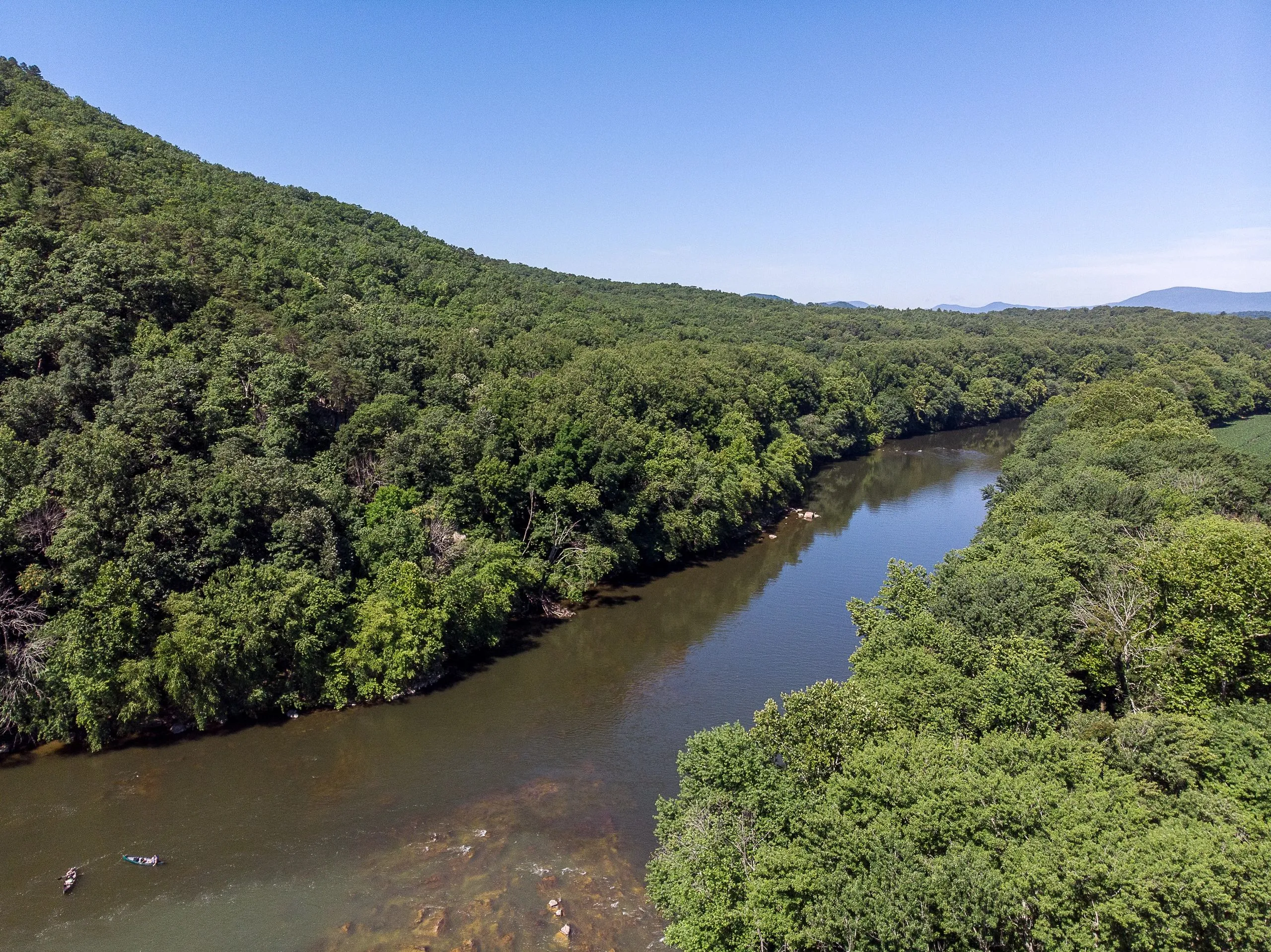 The Maury River curving past lush green hillsides on a summer afternoon near Glasgow.